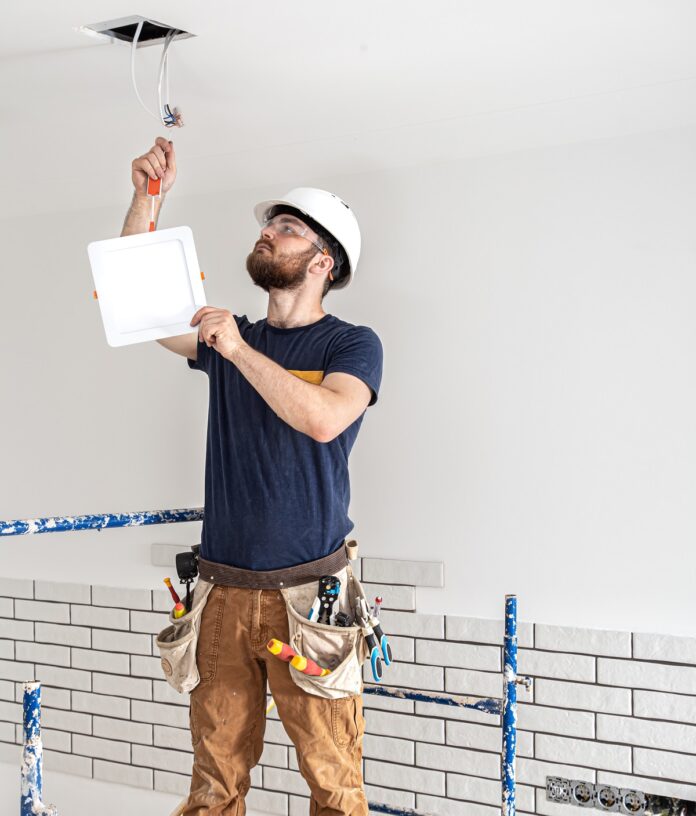 electrician-builder-with-beard-worker-white-helmet-work-installation-lamps-height-professional
