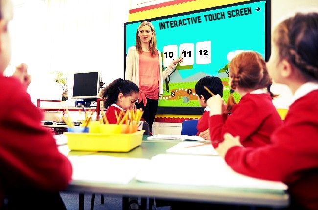 teacher teach a students on interactive flat panel display in the classroom